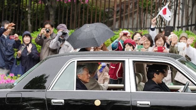 Image captionLos japoneses saludan al emperador Akihito y la emperatriz Michiko.