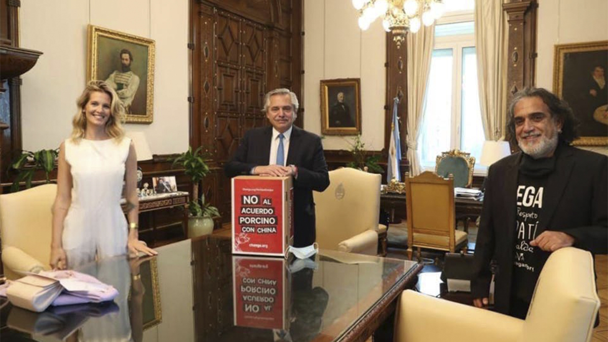 Liz Solari y a Manuel Alfredo Martí, titular de la Unión Vegana Argentina (UVA), junto a Alberto Fernández y un cartel que rechaza el acuerdo porcino con la República Popular China