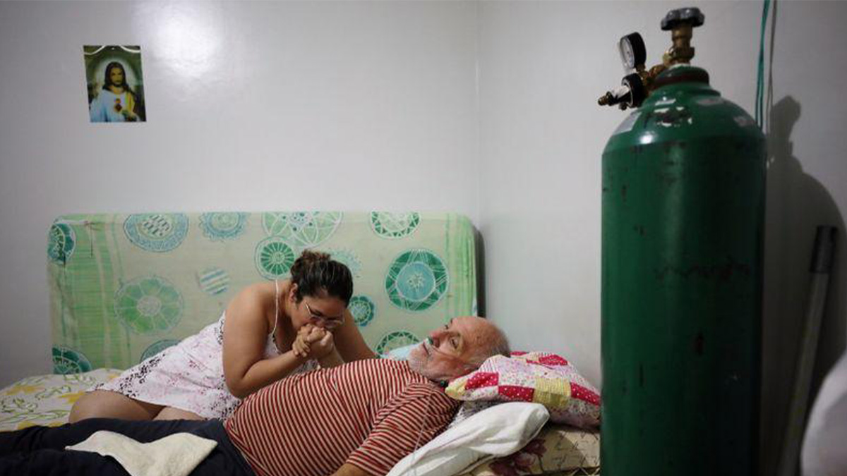 Una mujer acompaña a su padre enfermo de covid en su casa en Manaos (Brasil), en enero de 2021. BRUNO KELLY / REUTERS