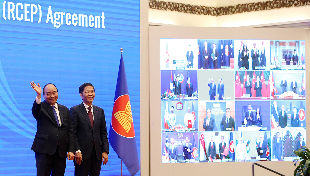 El primer ministro de Vietnam, Nguyen Xuan Phuc (L) y el ministro de Industria y Comercio, Tran Tuan Anh (R), aplauden la ceremonia virtual de firma de la Asociación Económica Regional Integral (RCEP) en Hanoi, Vietnam, el 15 de noviembre de 2020, en una foto de archivo. EFE/EPA/LUONG THAI LINH