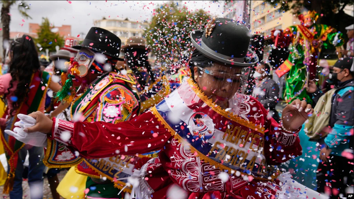 Una mujer con un protector facial para frenar la propagación del nuevo coronavirus actúa durante la inauguración de las celebraciones del Carnaval en La Paz, Bolivia, el domingo 6 de febrero de 2022. (AP Foto/Juan Karita)