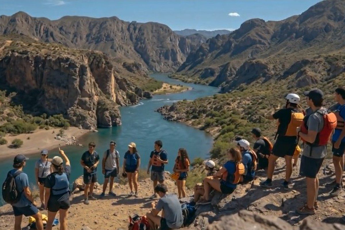 Contingente de jóvenes en una excursión de trekking junto a un río en un cañón argentino